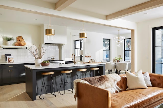 55XX Mcguire Rd, Edina, MN 55439 - kitchen with open floor plan, beam ceiling, a kitchen bar, decorative backsplash, and light wood finished floors