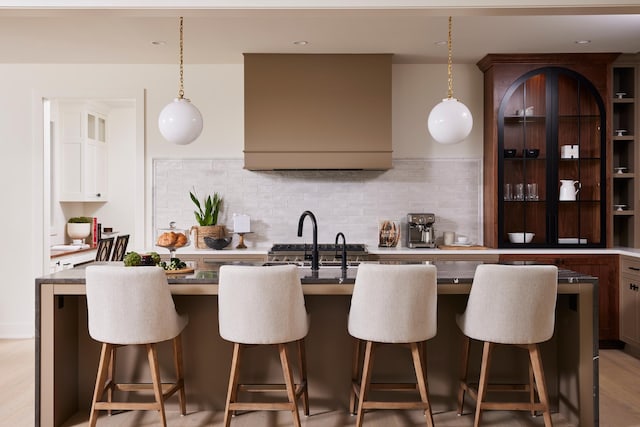 55XX Mcguire Rd, Edina, MN 55439 - kitchen with an island with sink, a breakfast bar, and decorative backsplash