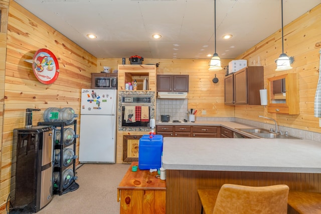 6076 Wynne Ridge Rd, White Twp, MN 55705 - kitchen featuring freestanding refrigerator, wall oven, a sink, stainless steel microwave, and wooden walls