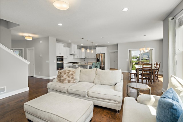 15827 Ethan Trl N, Hugo, MN 55038 - living room featuring baseboards, dark wood-style floors, recessed lighting, a chandelier, and stairway