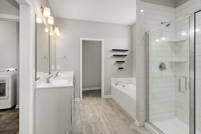 15827 Ethan Trl N, Hugo, MN 55038 - full bathroom with washer / dryer, a bath, double vanity, a stall shower, and baseboards