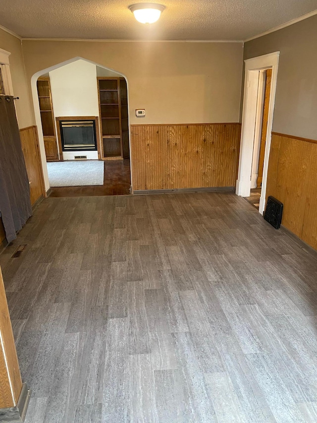 8 Dayton Ave SE, Wadena, MN 56482 - spare room with a wainscoted wall, arched walkways, wood finished floors, and crown molding