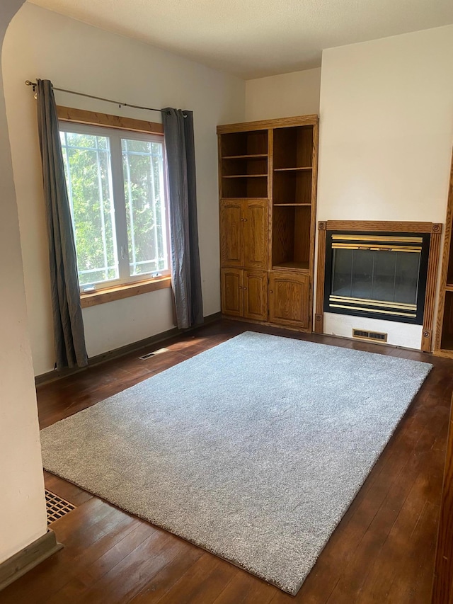 8 Dayton Ave SE, Wadena, MN 56482 - unfurnished living room with wood-type flooring, a glass covered fireplace, and baseboards