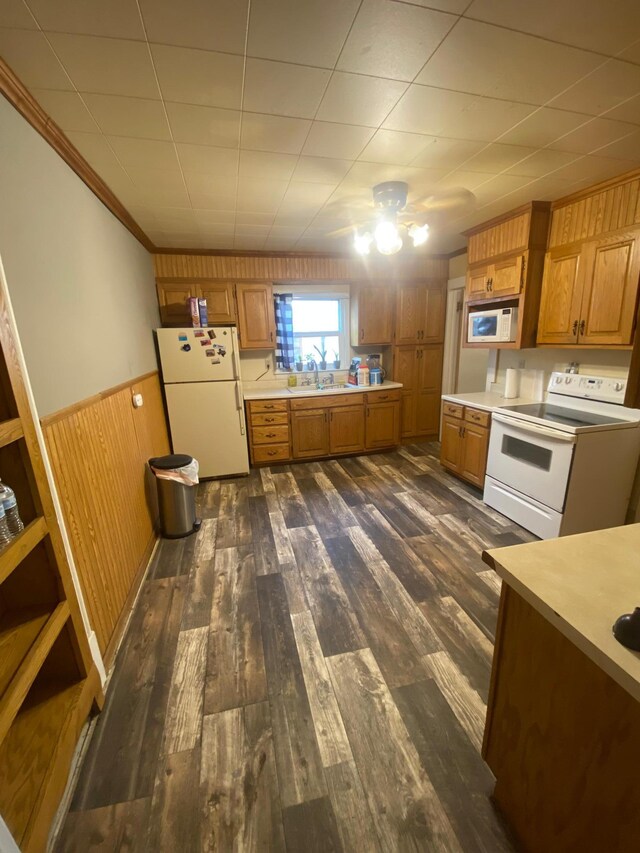 8 Dayton Ave SE, Wadena, MN 56482 - kitchen featuring white appliances, light countertops, dark wood-type flooring, wainscoting, and crown molding