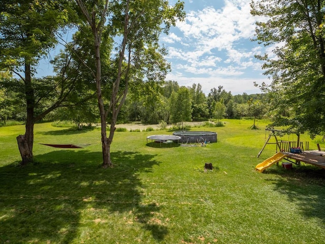 18241 Dahlia St NW, Oak Grove, MN 55011 - view of green lawn with a trampoline
