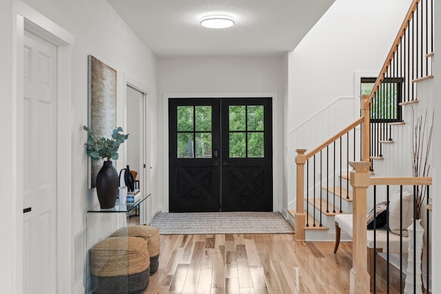 9743 Frontier Ln, Lakeville, MN 55044 - foyer with wood finished floors, stairway, and french doors
