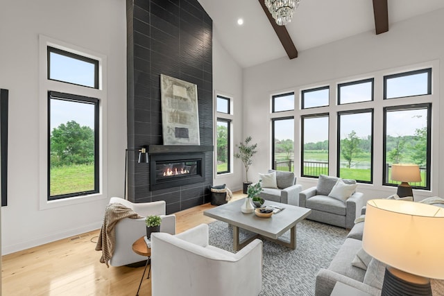 9743 Frontier Ln, Lakeville, MN 55044 - living room featuring high vaulted ceiling, light wood-style flooring, beamed ceiling, a fireplace, and a chandelier