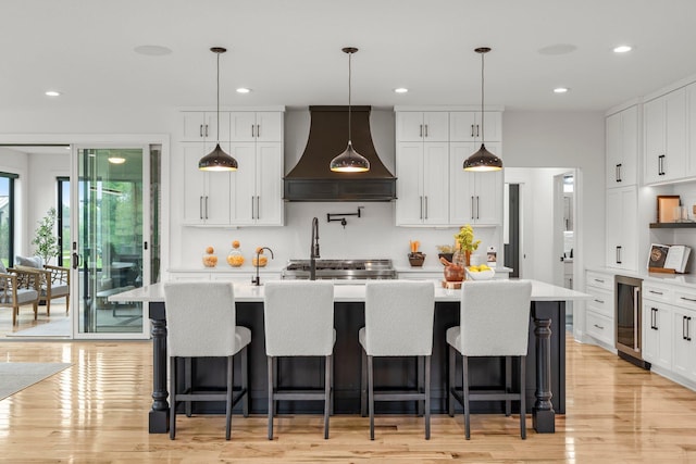 9743 Frontier Ln, Lakeville, MN 55044 - kitchen featuring premium range hood, wine cooler, light countertops, light wood-type flooring, and recessed lighting