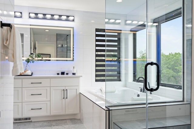 9743 Frontier Ln, Lakeville, MN 55044 - bathroom featuring vanity, a garden tub, and marble finish floors