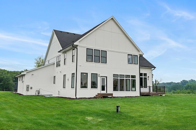 9743 Frontier Ln, Lakeville, MN 55044 - rear view of house with board and batten siding, a yard, roof with shingles, and a deck