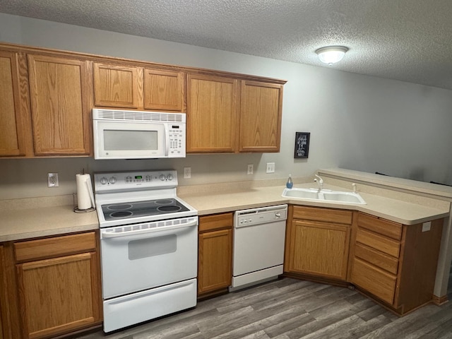 13622 Partridge Cir NW, Andover, MN 55304 - kitchen featuring white appliances, a peninsula, dark wood-type flooring, a textured ceiling, and light countertops