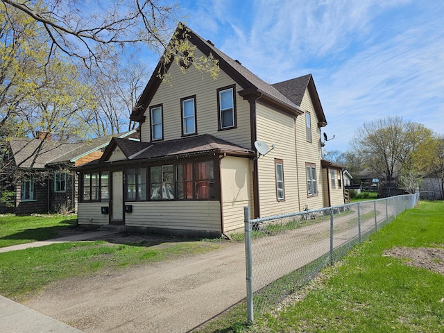 324 Holcombe Ave, Litchfield, MN 55355 - view of front of home featuring a shingled roof, dirt driveway, and a sunroom