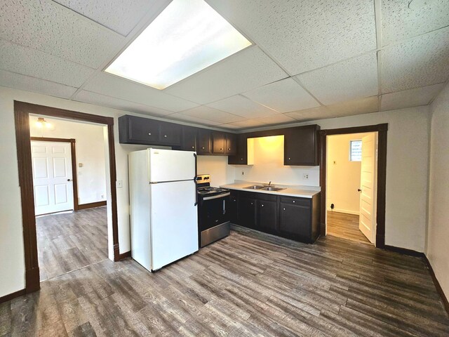 324 Holcombe Ave, Litchfield, MN 55355 - kitchen featuring freestanding refrigerator, stainless steel range with electric stovetop, a paneled ceiling, dark wood-type flooring, and light countertops