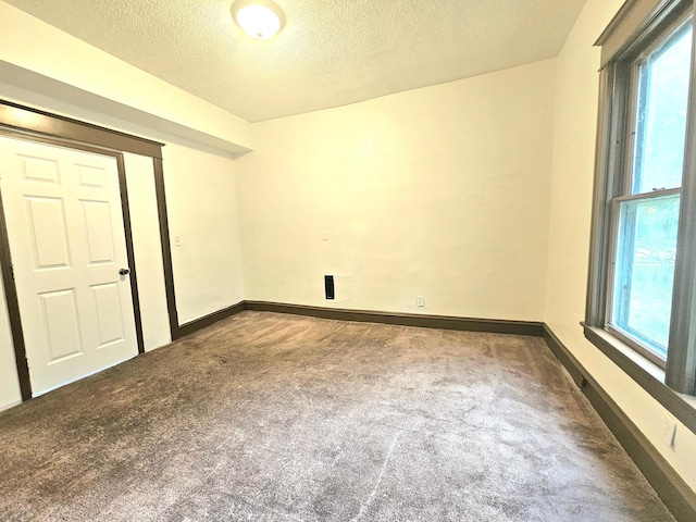 324 Holcombe Ave, Litchfield, MN 55355 - carpeted spare room featuring a textured ceiling and plenty of natural light