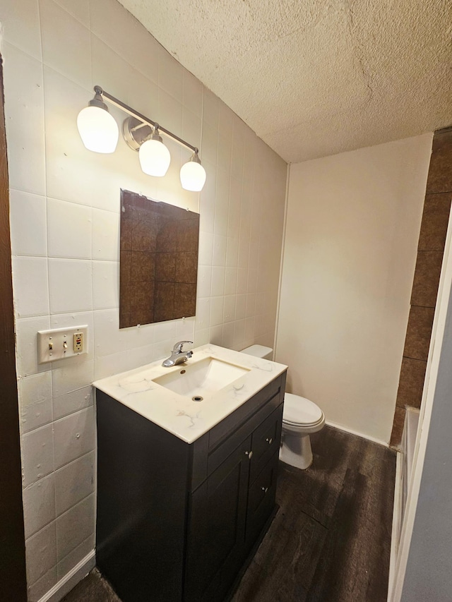 324 Holcombe Ave, Litchfield, MN 55355 - bathroom featuring tile walls, wood finished floors, vanity, and a textured ceiling