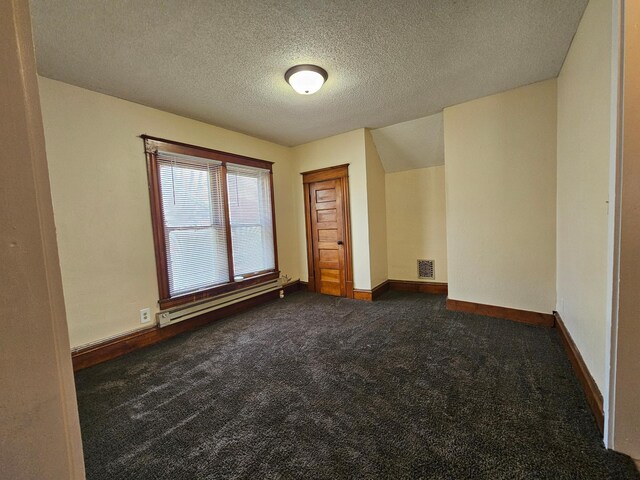 324 Holcombe Ave, Litchfield, MN 55355 - spare room with baseboard heating, dark colored carpet, and a textured ceiling