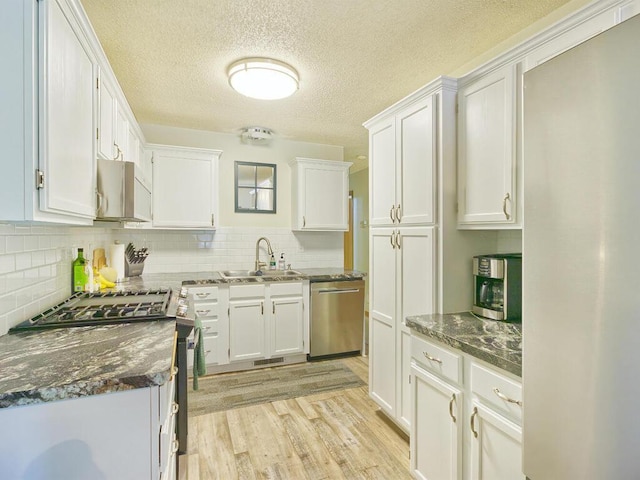 638 Shady Creek Cir, Winsted, MN 55395 - kitchen with stainless steel dishwasher, white cabinetry, light wood-type flooring, tasteful backsplash, and a textured ceiling