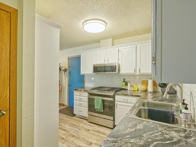 638 Shady Creek Cir, Winsted, MN 55395 - kitchen with appliances with stainless steel finishes, backsplash, light wood-type flooring, white cabinets, and a textured ceiling