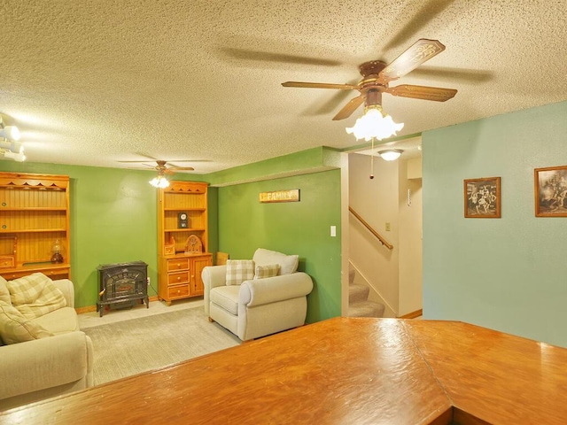 638 Shady Creek Cir, Winsted, MN 55395 - living room featuring a wood stove, a ceiling fan, a textured ceiling, and stairs