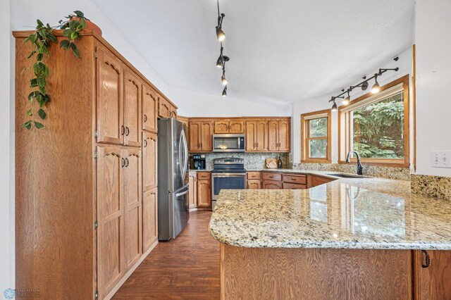 3306 26th Ave S, Fargo, ND 58103 - kitchen with appliances with stainless steel finishes, a peninsula, lofted ceiling, track lighting, and dark wood-type flooring