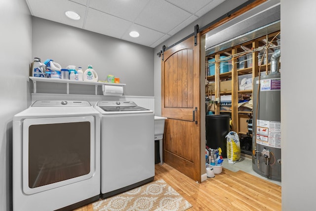 13870 Daphne Ln, Rosemount, MN 55068 - laundry room with gas water heater, washing machine and clothes dryer, a barn door, wood finished floors, and recessed lighting