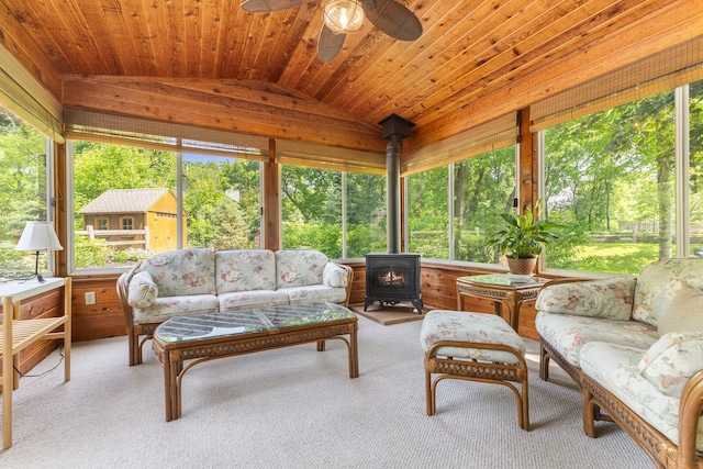 13870 Daphne Ln, Rosemount, MN 55068 - sunroom featuring a wood stove, lofted ceiling, carpet floors, and view of wooded area