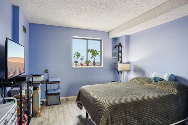 78 10th St E Unit 3009, Saint Paul, MN 55101 - bedroom featuring wood finished floors, a textured ceiling, and baseboards