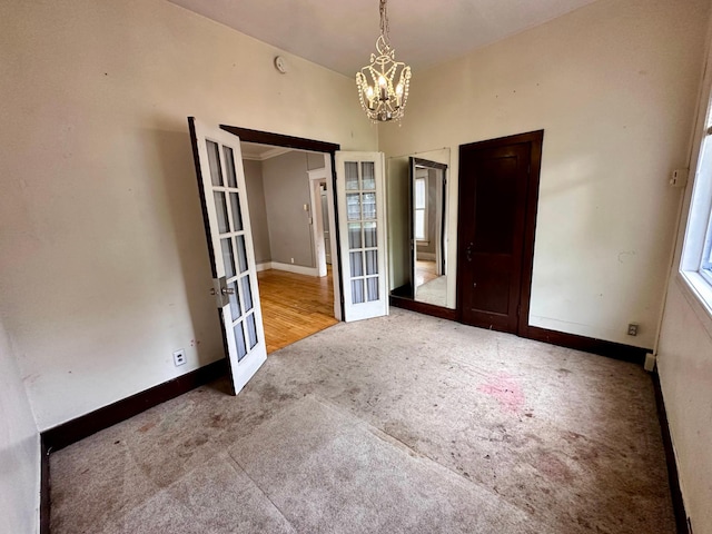 506 Marshall St, Marshall, MN 56258 - carpeted empty room featuring french doors, a chandelier, and baseboards