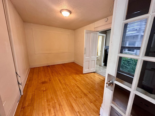 506 Marshall St, Marshall, MN 56258 - empty room with light wood-style floors, baseboards, and a textured ceiling