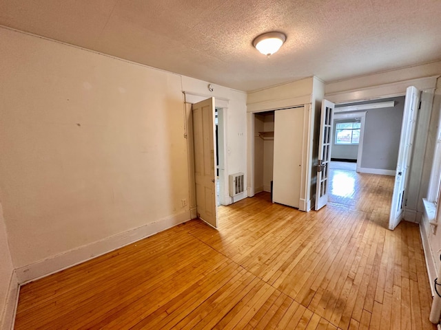 506 Marshall St, Marshall, MN 56258 - unfurnished bedroom featuring light wood-style floors, a textured ceiling, a closet, and baseboards