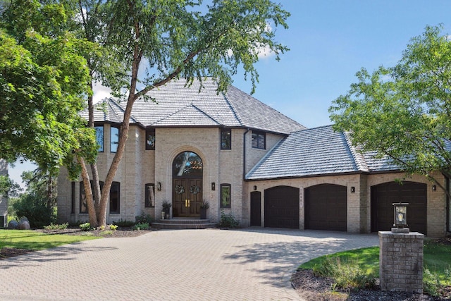10481 Bluff Rd, Eden Prairie, MN 55347 - view of front facade with a garage, decorative driveway, brick siding, and a high end roof