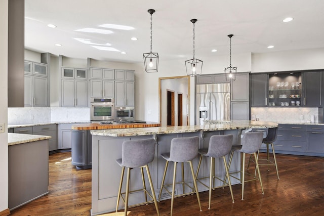 10481 Bluff Rd, Eden Prairie, MN 55347 - kitchen with built in appliances, gray cabinets, a spacious island, tasteful backsplash, and recessed lighting