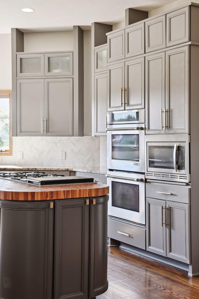 10481 Bluff Rd, Eden Prairie, MN 55347 - kitchen with butcher block countertops, appliances with stainless steel finishes, gray cabinets, and tasteful backsplash