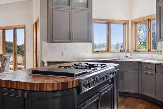10481 Bluff Rd, Eden Prairie, MN 55347 - kitchen featuring butcher block countertops, stainless steel gas stovetop, gray cabinets, tasteful backsplash, and dark wood-style floors
