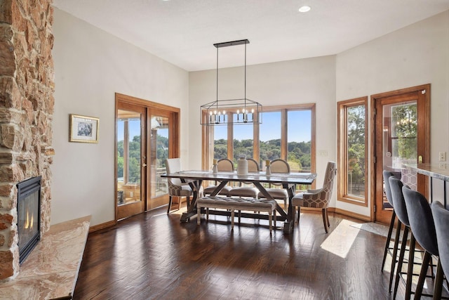 10481 Bluff Rd, Eden Prairie, MN 55347 - dining space featuring a fireplace, wood finished floors, a chandelier, recessed lighting, and a towering ceiling