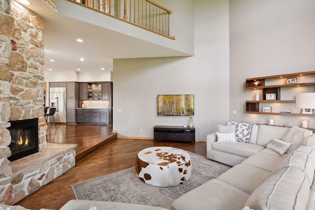 10481 Bluff Rd, Eden Prairie, MN 55347 - living room featuring a high ceiling, a stone fireplace, and wood finished floors