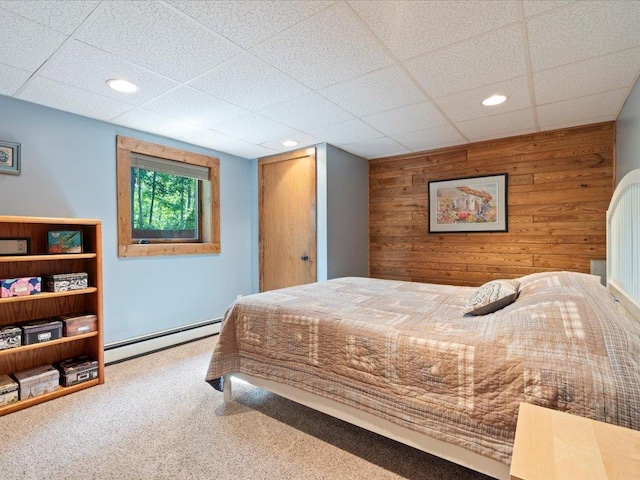 15473 Wilderness Trl, Crosslake, MN 56442 - bedroom featuring baseboard heating, wood walls, carpet flooring, recessed lighting, and a drop ceiling