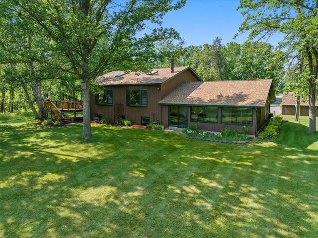15473 Wilderness Trl, Crosslake, MN 56442 - rear view of house with a deck, a lawn, roof with shingles, and a sunroom