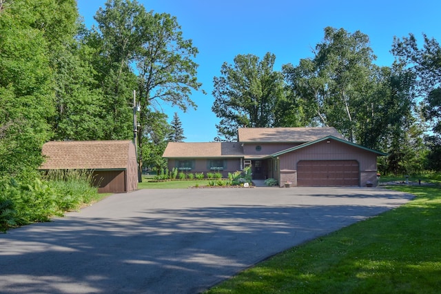 15473 Wilderness Trl, Crosslake, MN 56442 - single story home with asphalt driveway, an attached garage, and a storage unit