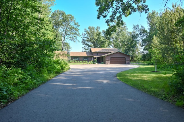 15473 Wilderness Trl, Crosslake, MN 56442 - ranch-style house with asphalt driveway, an attached garage, and a front yard
