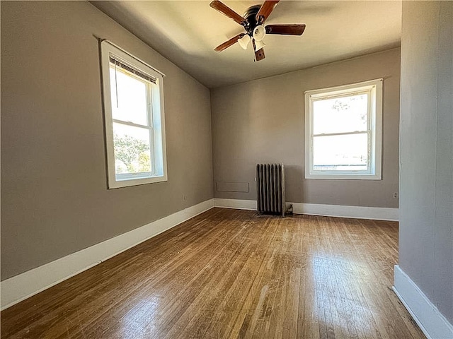 403 2nd St, Austin, MN 55912 - spare room with radiator, dark wood-type flooring, baseboards, and ceiling fan