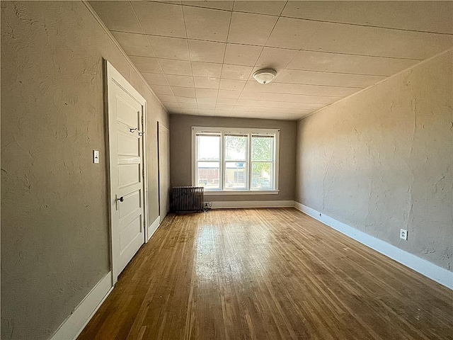 403 2nd St, Austin, MN 55912 - spare room featuring wood finished floors, baseboards, and a textured wall