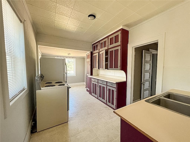 403 2nd St, Austin, MN 55912 - kitchen featuring white electric range, refrigerator, reddish brown cabinets, light flooring, and crown molding