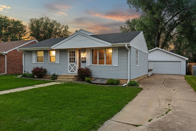2101 6th Ave NE, Austin, MN 55912 - view of front of property with an outbuilding, a garage, a shingled roof, and a yard