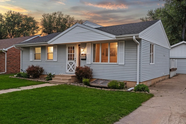 2101 6th Ave NE, Austin, MN 55912 - view of front of property featuring a lawn, a shingled roof, and a detached garage