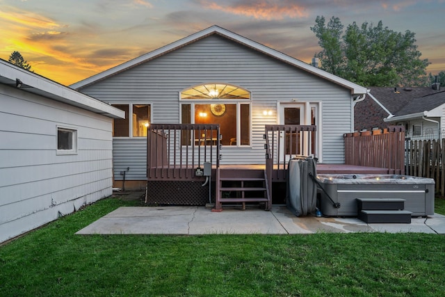 2101 6th Ave NE, Austin, MN 55912 - back of property at dusk with a patio area, a deck, and a hot tub