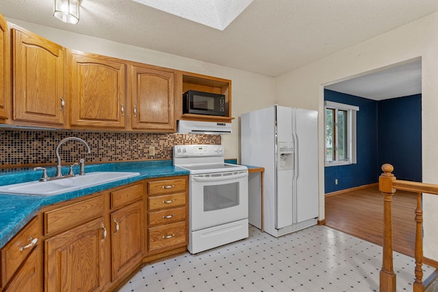2101 6th Ave NE, Austin, MN 55912 - kitchen featuring white appliances, a sink, under cabinet range hood, light flooring, and a skylight