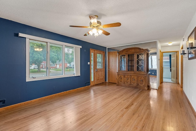 2101 6th Ave NE, Austin, MN 55912 - entrance foyer featuring a textured ceiling, light wood-style floors, a ceiling fan, and baseboards