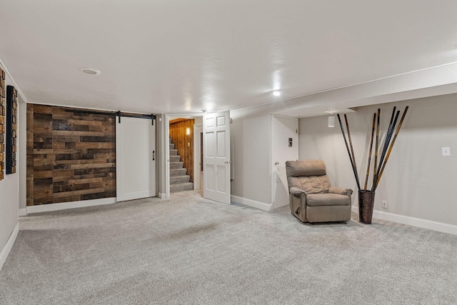 2101 6th Ave NE, Austin, MN 55912 - living area with carpet, baseboards, stairway, a barn door, and wood walls