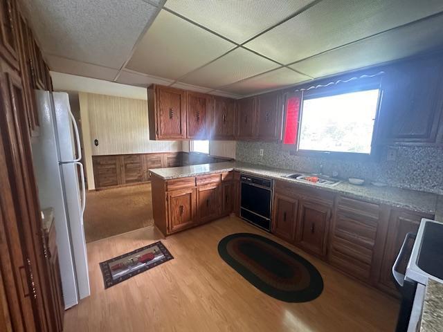 21 Glen Cir, Babbitt, MN 55706 - kitchen with freestanding refrigerator, black dishwasher, a sink, light wood-style floors, and range